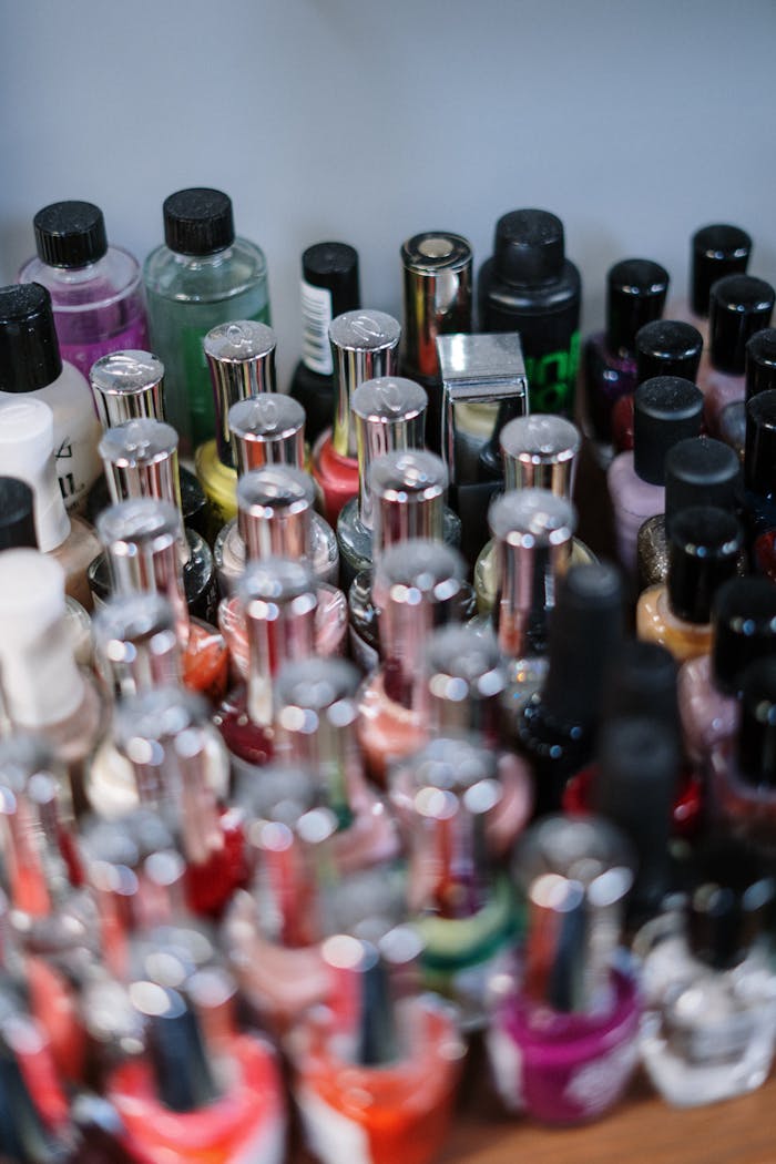 Close-up of assorted nail polish bottles in various colors, ideal for salon and cosmetic use.